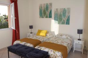 a bedroom with two beds and a window at Di Felicita in Albitreccia +16 photos