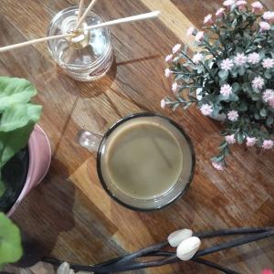 Art Beaubourg في باريس: كوب من القهوة على طاولة خشبية مع الزهور