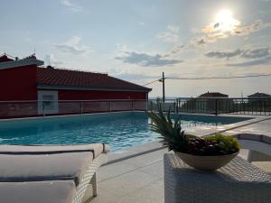a swimming pool with a bowl of fruit on a table at Stella Maris in Kaštela