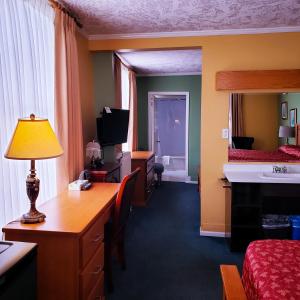a hotel room with a desk and a bed at James Bay Inn Hotel, Suites & Cottage in Victoria