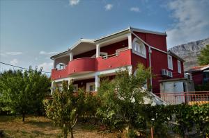 a red building with trees in front of it at Stella Maris in Kaštela