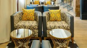 duas cadeiras e um sofá com duas mesas em Hotel Indigo Savannah Historic District, an IHG Hotel em Savannah