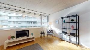 ein Wohnzimmer mit einem TV und einem großen Fenster in der Unterkunft Bright and luminous 1 bedroom flat in downtown in Sion