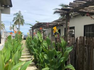 una casa con una valla y plantas delante de ella en Casa de Playa Manecal, en Coveñas