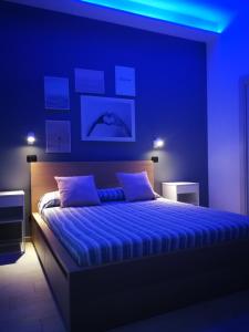 sypialnia z dużym łóżkiem z niebieskim oświetleniem w obiekcie Tere Suite w mieście Napoli