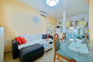 uma sala de estar com um sofá e uma mesa de vidro em Apartment Marija em Seget Vranjica