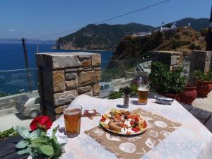 una mesa con un plato de comida y dos vasos de cerveza en Studios Milos Skopelos-Where the Sea Meets the Sky, en Skopelos Town