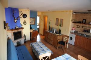 a living room with a blue couch and a kitchen at Casas Rurales Tiscar in Arroyo Frio