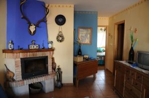 sala de estar con chimenea y TV en Casas Rurales Tiscar, en Arroyo Frío