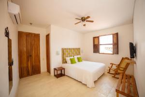 a bedroom with a bed and a ceiling fan at Bioma Boutique Hotel in Mompos