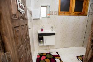 Baño pequeño con lavabo y espejo en Hostel Castelo Ltda, en Lauro Müller