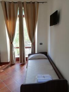 a bedroom with two beds in front of a window at Le Coste Affittacamere in San Lupo