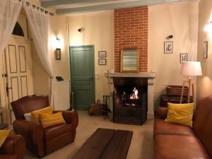a living room with couches and a fire place at Domaine de l'Augeonnière in Villandry