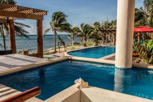 a swimming pool with a view of the ocean at Aquastar Unique Hotel & Apartments Mahahual in Mahahual