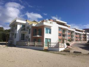 a white apartment building on a sandy beach at Sea Paradise Apartment Complex in Kavarna