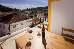 dwa kieliszki do wina na stole z widokiem na miasto w obiekcie Casinha da Encosta w mieście Alenquer