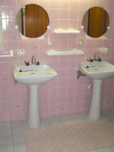 a pink bathroom with two sinks and mirrors at Rekreacny dom Altwaldorf Vysoke Tatry in Stará Lesná +7 photos