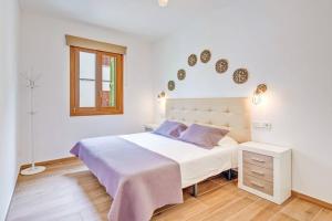 Un dormitorio blanco con una cama grande y una ventana en Son Trast, en Vilafranca de Bonany