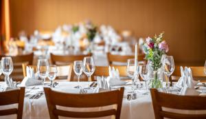 a dining room with tables with wine glasses and flowers at Landgasthof Deutsches Haus KG in Weilheim an der Teck