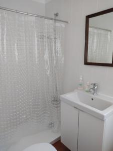 Un baño con una cortina de ducha blanca y un lavabo. en Casa Benlindha, en Degolados 35 fotos más