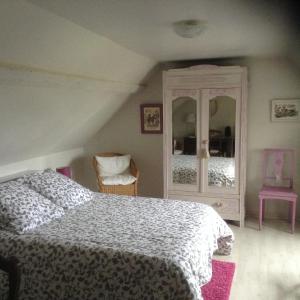 - une chambre avec un lit et une commode dans l'établissement Le Jardin des Poules, à Thiétreville