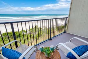 a balcony with chairs and a table and the beach at Sunrise Terrace in St. Augustine