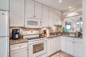 a white kitchen with white cabinets and a microwave at Sunrise Terrace in St. Augustine +41 photos