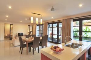 a kitchen and living room with a table and chairs at Destiny Villas and Residence in Seminyak
