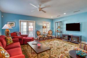 a living room with red furniture and a flat screen tv at St. George Street Apartment in Saint Augustine