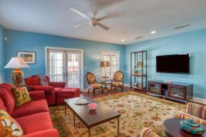 a living room with red furniture and a flat screen tv at St. George Street Apartment in St. Augustine