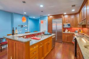a large kitchen with wooden cabinets and blue walls at St. George Street Apartment in St. Augustine
