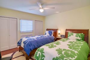 a bedroom with two beds and a ceiling fan at St. George Street Apartment in Saint Augustine