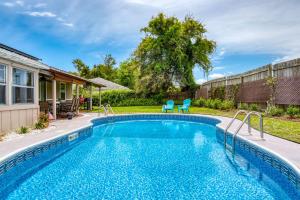 - une piscine dans une cour avec 2 chaises bleues dans l'établissement Gathering Shore, à Saint Augustine