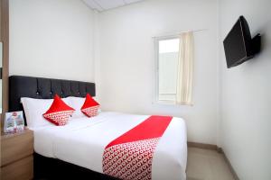 Tempat tidur dalam kamar di Capital O 106 Sarkawi Residence