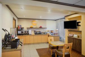 a waiting room with a counter and a kitchen at La Quinta by Wyndham Springdale in Springdale