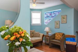 a living room with blue walls and a vase of flowers at Beachcomber Penthouse in St. Augustine +31 photos