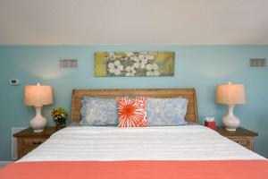 a bedroom with a large bed with two lamps at Beachcomber Penthouse in St. Augustine