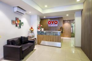un vestíbulo con una sala de espera con un signo ovo en SUPER OYO Flagship 101 Apple Platinum en Yakarta