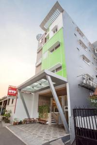 un edificio de color verde y blanco en SUPER OYO Flagship 101 Apple Platinum, en Yakarta