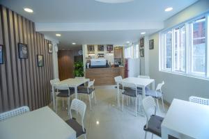 ein Esszimmer mit Tischen und Stühlen sowie eine Küche in der Unterkunft SUPER OYO Flagship 101 Apple Platinum in Jakarta