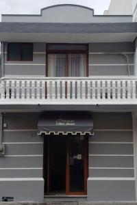 ein weißes Haus mit einem Balkon und einer Tür in der Unterkunft Hotel Posada San Juan in Veracruz