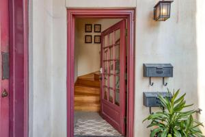 a red door leading to a hallway with a staircase at 64 Hypolita Street in St. Augustine