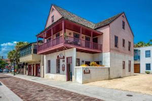a red and white building with a balcony on a street at 64 Hypolita Street in St. Augustine
