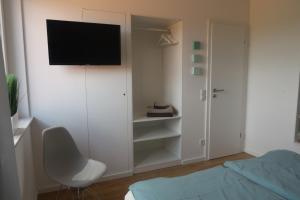 a bedroom with a bed and a television on a wall at Die kleine Auszeit in Gescher