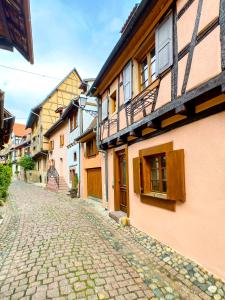 a cobblestone street in a town with buildings at Guesthouse Les 3 Chateaux in Eguisheim