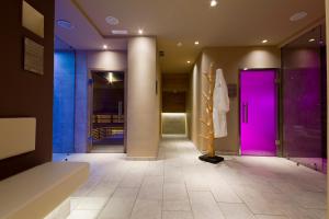 a bathroom with a purple door and a tile floor at Hotel Ambassador in Levico Terme