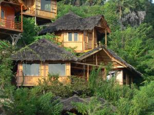 a wooden house with a grass roof on a hill at Waecicu Eden Beach Hotel in Labuan Bajo