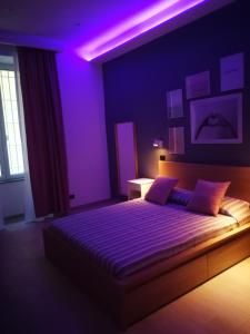 sypialnia z łóżkiem z fioletowymi lampkami w obiekcie Tere Suite w mieście Napoli