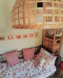 um quarto com uma cama com almofadas vermelhas e brancas em HIŠA ANTONIJA-APARTMA IRINKA em Fokovci