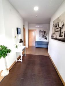 um corredor com uma mesa e um sofá num quarto em Hostal Hernan Cortes em Cáceres